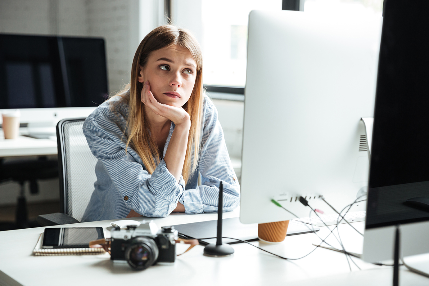 Image of serious young woman work in office using computer. Looking aside.