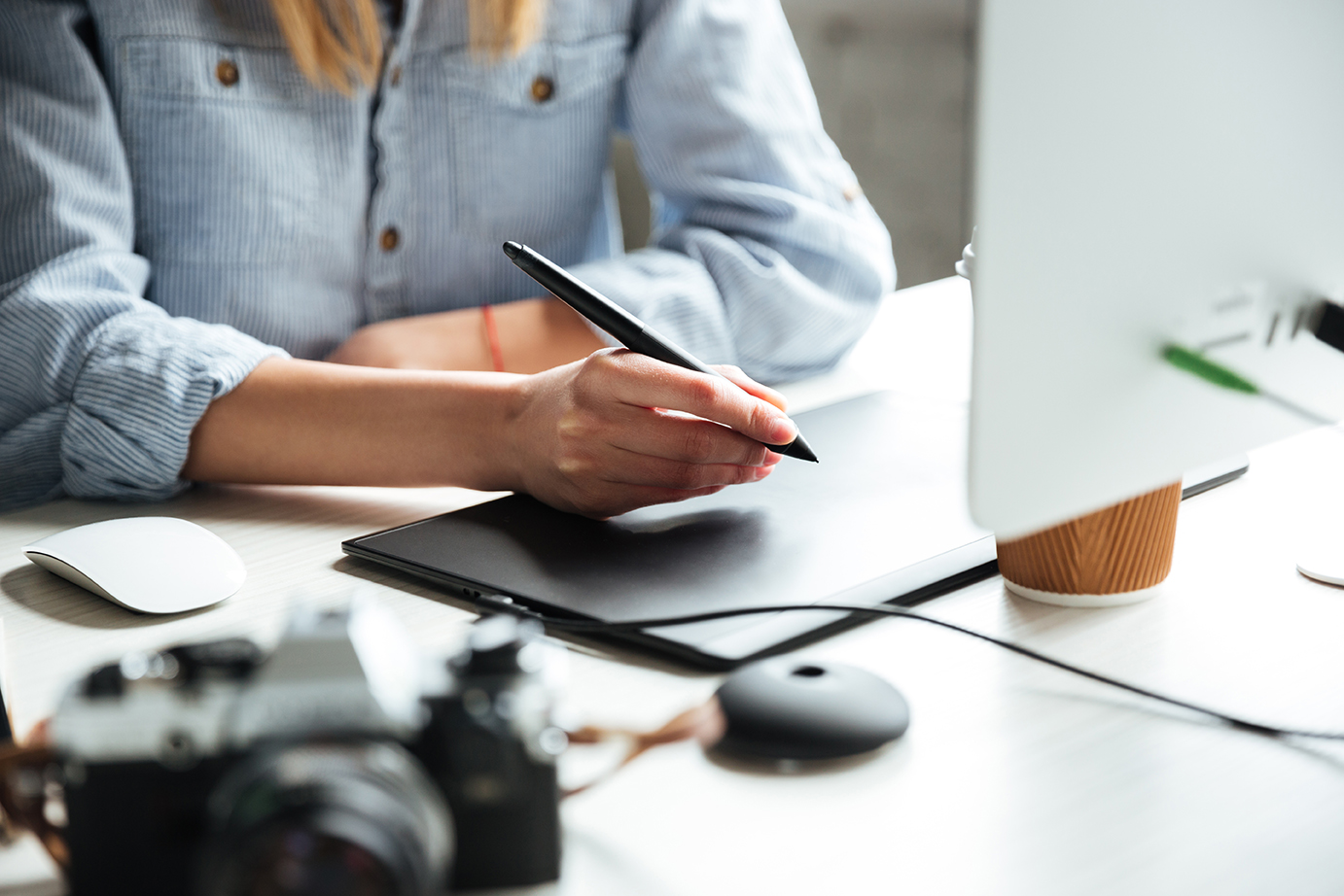 Cropped image of young woman work in office using computer and graphic tablet