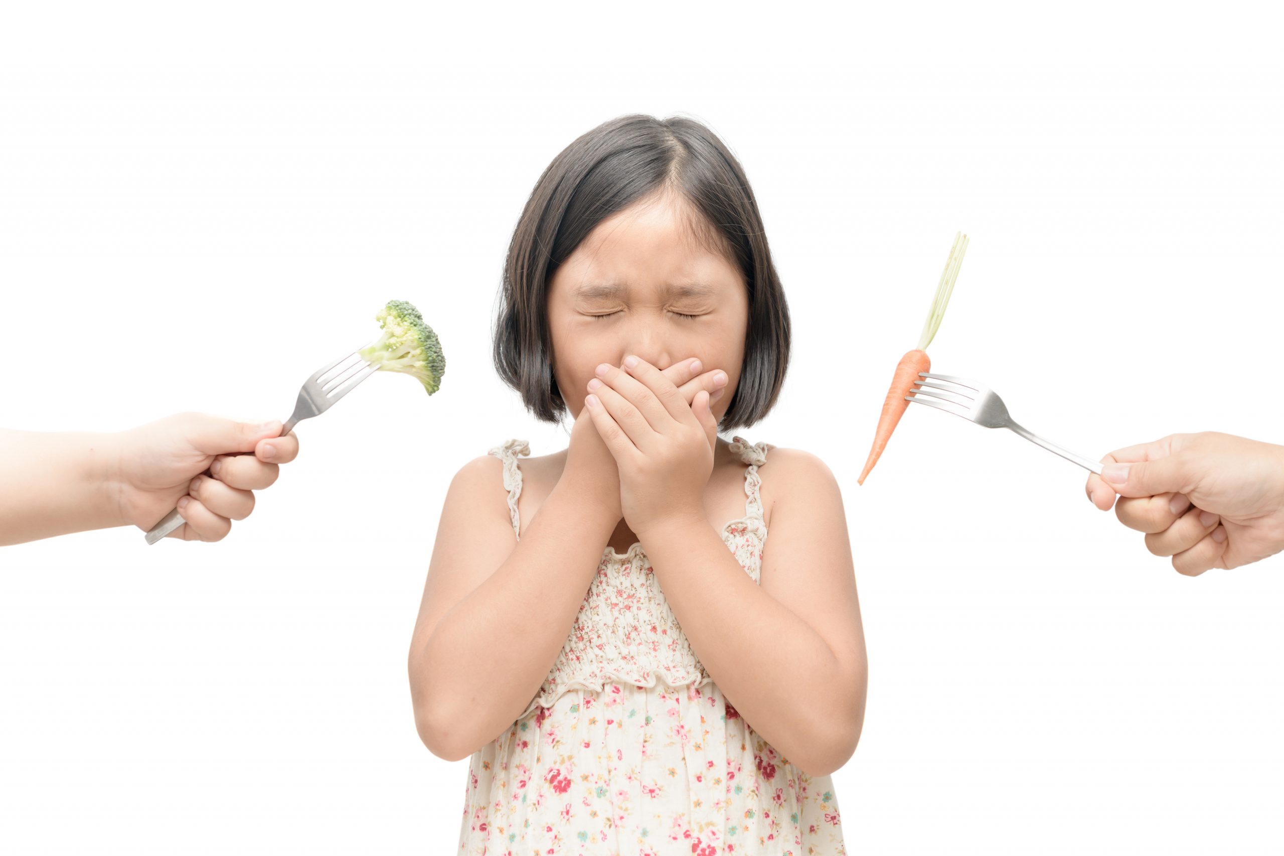 asian child girl with expression of disgust against vegetables isolated on white background, Refusing food concept
